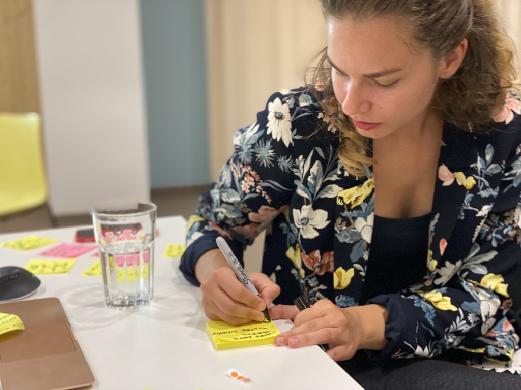 Woman writing down ideas on a Post It note